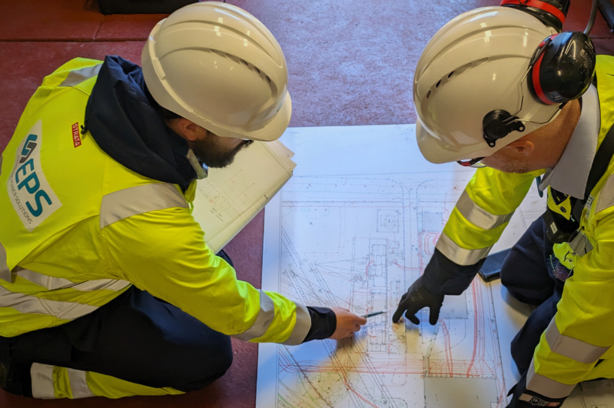 Two EPS senior electrical engineers studying an electrical design during a site survey.